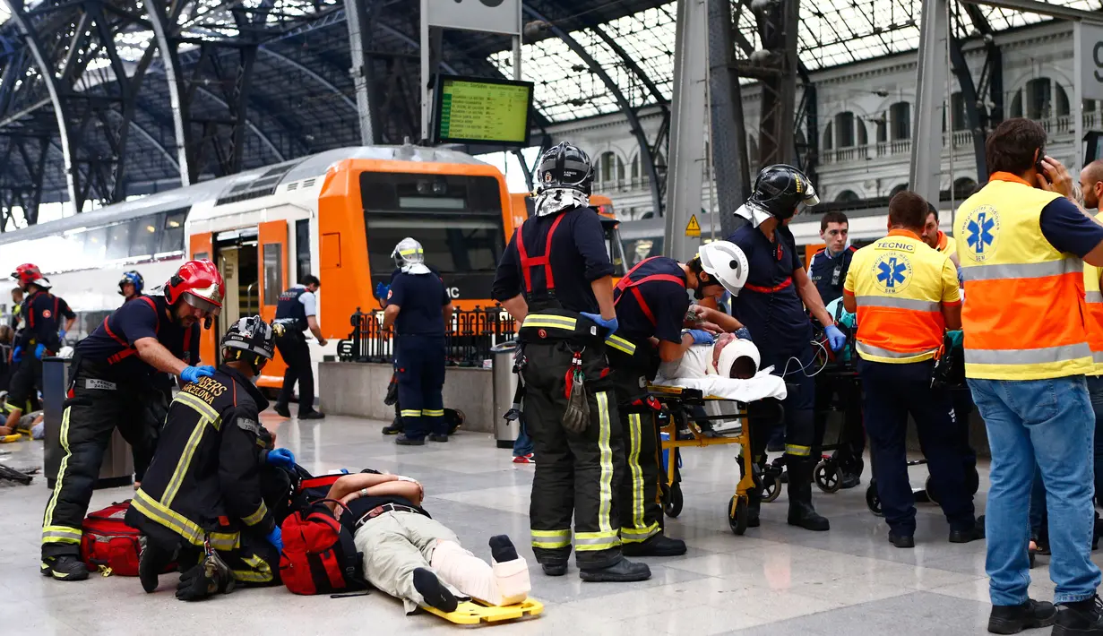 Sejumlah penumpang saat dievakuasi usai kecelakaan kereta api di stasiun kereta api di Barcelona, Spanyol, Jumat, (28/7). Puluhan orang terluka saat sebuah kereta komuter pagi yang mereka tumpangi menabrak buffer. (AP Photo/Adrian Quiroga)