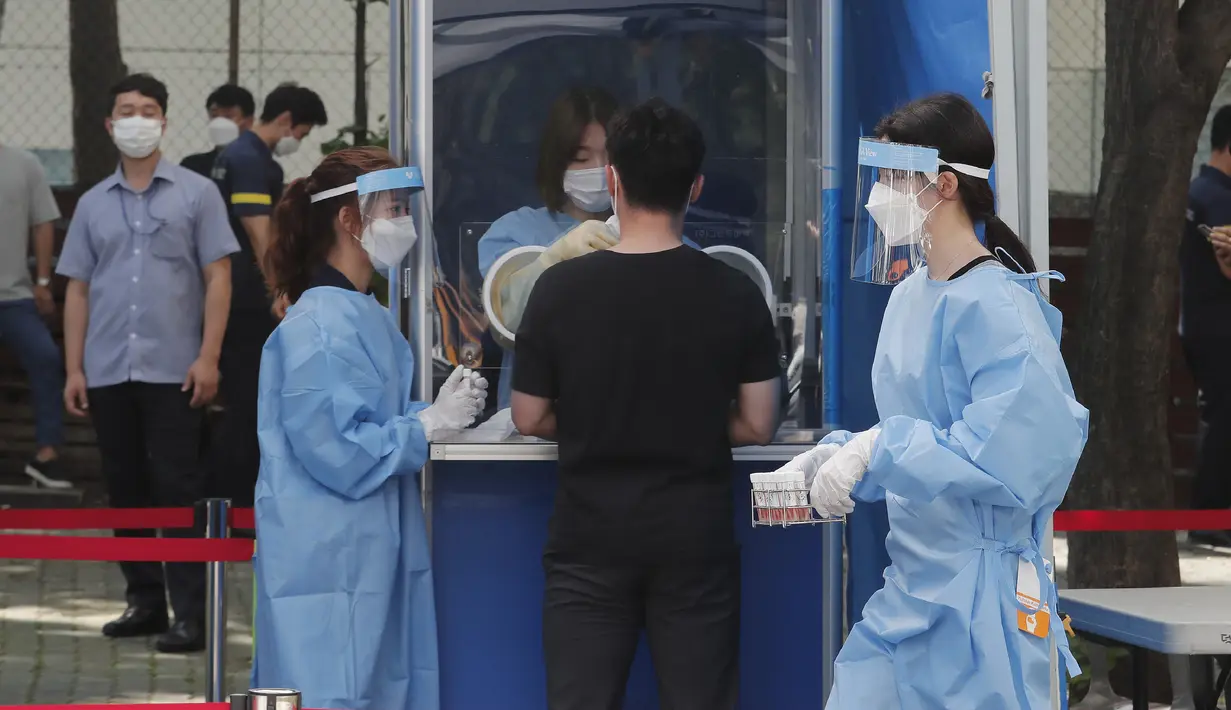 Seorang pekerja medis membawa sampel dari petugas polisi selama pengujian COVID-19 di Badan Kepolisian Metropolitan Seoul di Seoul, Korea Selatan, Rabu, (19/8/2020). (AP Photo / Ahn Young-joon)