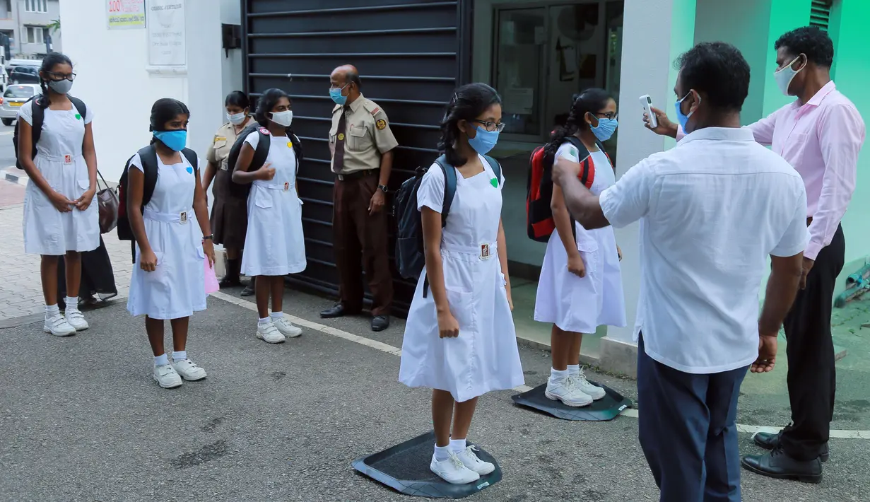 Para siswa diperiksa suhu tubuhnya sebelum memasuki sebuah sekolah di Kolombo, Sri Lanka, Senin (6/7/2020). Mulai 6 Juli 2020, siswa kelas 5, 11, dan 13 di Sri Lanka kembali melanjutkan kegiatan belajar. (Xinhua/Ajith Perera)
