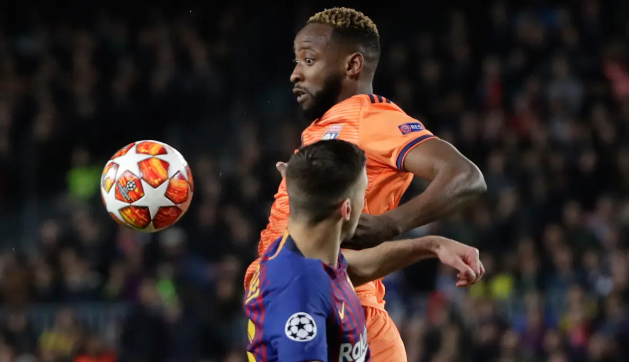 Pemain Olympique Lyon Moussa Dembele berebut bola dengan pemain Barcelona, Clement Lenglet pada leg kedua 16 besar Liga Champions di Camp Nou, Rabu (13/3). Barcelona menaklukkan Olympique Lyon dengan skor telak 5-1. (AP/Emilio Morenatti)