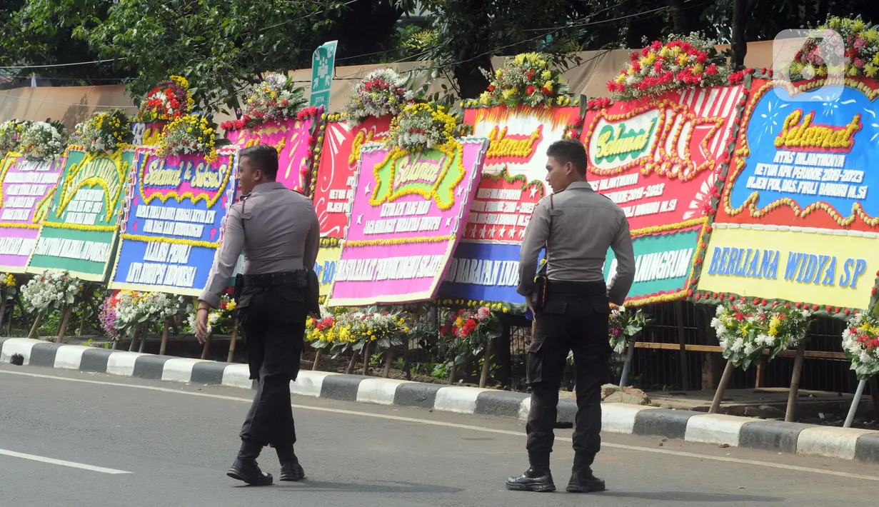 Petugas kepolisian berdiri di dekat karangan bunga ucapan selamat yang berjejer di sekitar Gedung Merah Putih KPK, Jakarta, Jumat (20/12/2019). Papan karangan bunga tersebut berisi ucapan selamat terhadap dilantiknya pimpinan KPK periode 2019-2023. (merdeka.com/Imam Buhori)