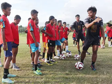 Ilham Udin Armaiyn memberi instruksi kepada anak-anak yang akan melakukan latihan passing saat coaching clinic di Kota Sofifi, Maluku Utara, Senin (14/8/2023) sore hari WIT. . (Bola.com/Okie Prabhowo)