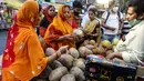 Dua wanita membeli kelapa di pinggir jalan menjelang festival Hindu Chhath, di Kolkata, India (9/11/2021). Selama Chhath, festival Hindu kuno yang populer di kalangan kelas pekerja, ritual dilakukan untuk berterima kasih kepada Dewa Matahari atas menopang kehidupan di bumi. (AP Photo/Bikas Das)