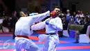 Karateka Jawa Timur, Umar Syarief (kiri) menyarangkan pukulan ke arah Caesar George (Jakarta) di kelas Kumite Individu Putra +84 kg senior PON XIX di Sabuga, Bandung, Minggu (18/9). Umar menang telak 9-1 atas Caesar. (Liputan6.com/Helmi Fithriansyah)