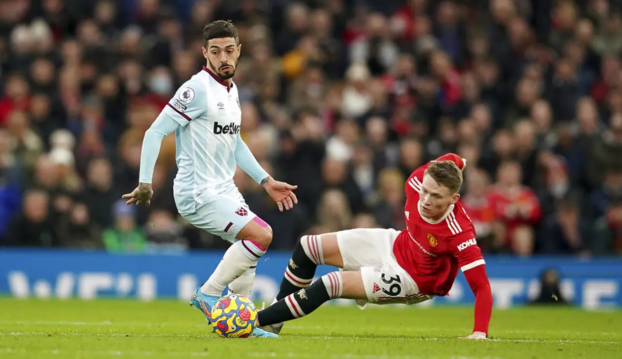 Pemain Manchester United Scott McTominay (kanan) kehilangan keseimbangan saat dia ditekel oleh pemain West Ham United Manuel Lanzini pada pertandingan sepak bola Liga Inggris di Stadion Old Trafford, Manchester, Inggris, 22 Januari 2022. Manchester United menang 1-0. (AP Photo/Dave Thompson)