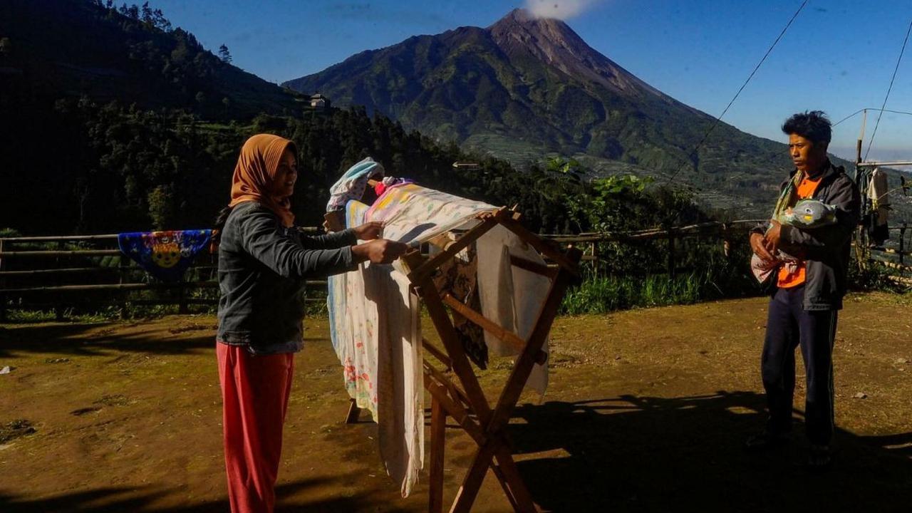 Aktivitas warga di sana pun sangat tentram dan damai.<br><br>Terlihat dari seorang ibu yang sedang menjemur pakaian saat suaminya menggendong anaknya untuk berjemur di bawah sinar matahari pagi. Foto: merdeka.com / Arie Basuki