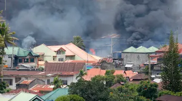 Kepulan asap terlihat menyusul serangan udara oleh Angkatan Udara Filipina ke kawasan yang telah di kuasai militan Maute di kota Marawi , Filipina selatan Sabtu, (27/5). (AP Photo / Bullit Marquez)