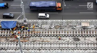 Pekerja menyelesaikan rel jalur layang mass rapid transit (MRT) yang melintasi tol Jakarta Outer Ring Road (JORR) TB Simatupang, Jakarta, Sabtu (21/4). Jalur MRT  memiliki 7 stasiun layang dan 6 stasiun bawah tanah. (Liputan6.com/Fery Pradolo)