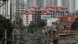 Warga beraktivitas di antara rel kereta dengan latar belakang gedung bertingkat di kawasan Pejompongan, Jakarta, Selasa (5/1/2021). Pemerintah mengalokasikan anggaran untuk PEN 2021 sebesar Rp403,9 triliun, anggaran ini naik dari rencana sebelumnya sebesar Rp372,3 triliun. (Liputan6.com/Johan Tallo)