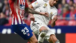 Gelandang Real Madrid,  Lucas Vazquez berebut bola dengan striker Atletico Madrid, Vitolo selama pertandingan lanjutan La Liga Spanyol di stadion Wanda Metropolitano (9/2). Real Madrid menang 3-1 atas Atletico. (AFP Photo/Pierre-Philippe Marcou)