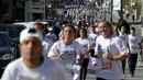 Sejumlah peserta berlari menyusuri tembok pemisah Israel selama Right to Movement Maraton di kota Bethlehem, Palestina, Jumat (1/4). Tembok sejauh 700 km ini dijadikan obyek berlari para peserta. (REUTERS / Ammar Awad)