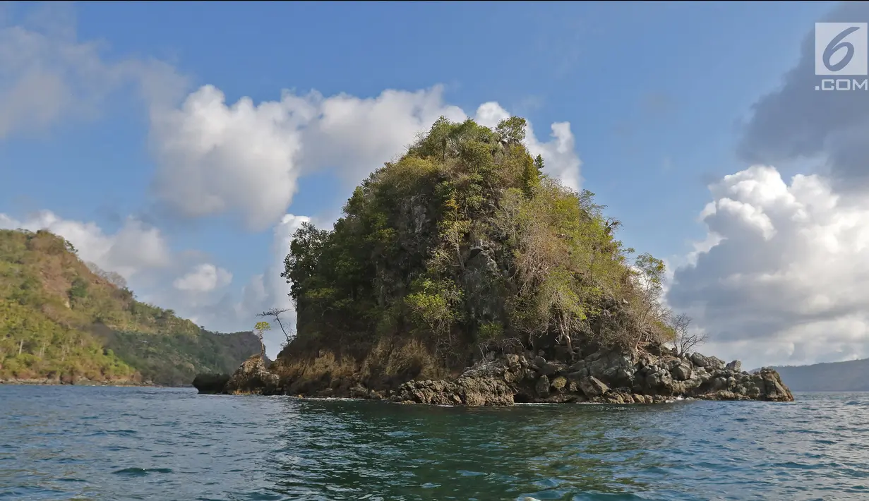Pulau yang memiliki gua kedalaman 4 meter terlihat di kawasan perairan di Pantai Mutiara, Trenggalek, Jawa Timur, Sabtu (7/9/2019). Pantai Mutiara salah satu tujuan wisata yang sedang dikembangkan kabupaten Trenggalek. (Liputan6.com/Herman Zakharia)
