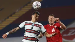 Bek Portugal, Jose Fonte (kiri) berduel udara dengan gelandang Serbia, Sergej Milinkovic-Savic dalam laga Kualifikasi Piala Dunia 2022 Zona Eropa Grup A di Rajko Mitic Stadum, Belgrade, Sabtu (27/3/2021). Portugal bermain imbang 2-2 dengan Serbia. (AFP/Pedja Milosavljevic)