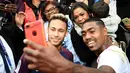 Penyerang PSG, Neymar berfoto bersama dengan pemain Bordeaux, Malcom usai pertandingan Ligue 1 di stadion Parc des Princes di Paris (30/9). Kedua pemain asal Brasil ini terlihat akrab usai pertandingan.  (AFP Photo/Franck Fife)