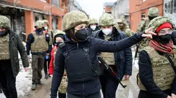 Menteri Luar Negeri Jerman Annalena Baerbock terlihat mengenakan helm dan rompi anti peluru saat berkunjung di Shyrokyne, Wilayah Donetsk, Ukraina (8/2/2022). Annalena Baerbock mengunjungi desa pesisir Shyrokyne, yang terletak di Oblast Donetsk yang diperangi. (AFP/Pool/Bernd von Jutrczenka)