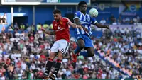 Gelandang Manchester United Portugal #08, Bruno Fernandes (Kiri), bersaing dengan gelandang Brighton Kamerun #17, Carlos Baleba, selama pertandingan Liga Inggris antara Brighton dan Hove Albion dan Manchester United di American Express Community Stadium di Brighton, Inggris selatan pada 24 Mei 2026. (Glyn KIRK/AFP)