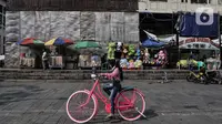 Wisatawan menaiki sepeda di kawasan wisata Kota Tua, Jakarta, Minggu (28/6/2020). Para pedagang, delman, dan jasa penyewaan sepeda pun terlihat kembali meramaikan suasana di sekitar Kali Besar. (merdeka.com/Iqbal S. Nugroho)