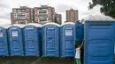 Seorang gadis masuk ke toilet di kamp yang didirikan untuk migran Venezuela di Bogota, Kolombia (21/11). Sebelumnya imigran tinggal di tenda-tenda yang terbuat dari lembaran plastik dan bahan bekas di luar terminal bus kota. (AP Photo/Ivan Valencia)