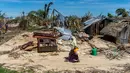 Seorang wanita melintasi rumah-rumah yang hancur akibat topan Kenneth pada bulan lalu di desa pesisir Guludo, Pulau Ibo, 13 Mei 2019. Umat Islam di Mozambik melalui bulan Ramadan dengan badai yang menyebabkan sebagian besar masjid hancur dan persediaan makanan sangat terbatas. (Zinyange Auntony/AFP)