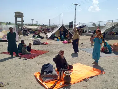 Keluarga Afghanistan duduk di luar tenda di area terbuka di pinggiran Chaman, sebuah kota perbatasan di provinsi Baluchistan barat daya Pakistan, Rabu (1/9/2021). Puluhan keluarga Afghanistan telah menyeberang ke Pakistan melalui perbatasan barat daya Chaman sehari setelahnya. (AP Photo/Jafar Khan)