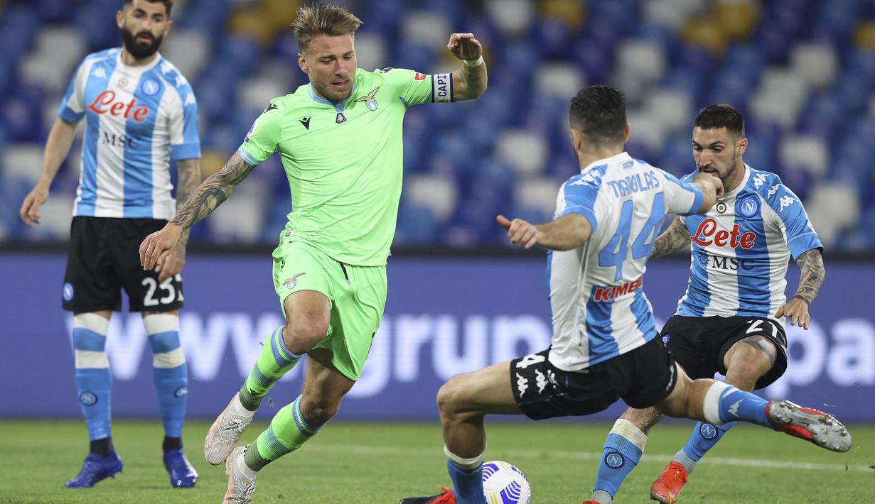 Striker Lazio, Ciro Immobile (tengah) berebut bola dengan bek Napoli, Konstantinos Manolas dalam laga lanjutan Liga Italia 2020/2021 pekan ke-32 di Diego Armando Maradona Stadium, Naples, Kamis (22/4/2021). Lazio kalah 2-5 dari Napoli. (Lapresse via AP/Alessandro Garofalo)