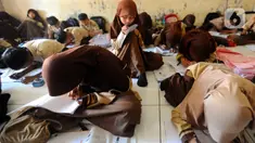 Saat menulis, mereka harus meletakkan bukunya di lantai dan membungkukkan punggungnya. (merdeka.com/Arie Basuki)