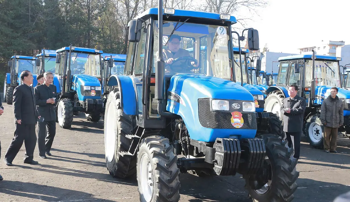 Foto yang dirilis kantor berita KCNA (15/11), Kim Jong-un saat mengendarai traktor di Kumsong Tractor Factory. Kunjungan tersebut dilakukan untuk menunjukkan bahwa ekonomi Korut tak terpengaruh oleh sanksi internasional. (AFP Photo/Kcna Via Kns/Str)