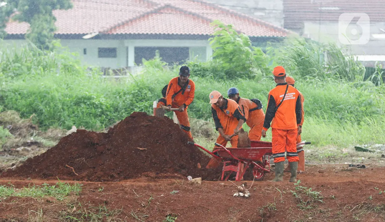 Sejumlah petugas Suku Dinas Pertamanan dan Hutan Kota merapikan lahan yang akan dibuat menjadi kawasan hijau di bawah kolong Tol Becakayu atau Bekasi-Cawang-Kampung Melayu, Jakarta, Kamis (5/1/2023). Perlu diketahui, progres penghijauan di area kolong Tol Becakayu telah dilakukan sepanjang 2,7 kilometer dari total yang akan dihijaukan 5 kilometer. (Liputan6.com/Herman Zakharia)