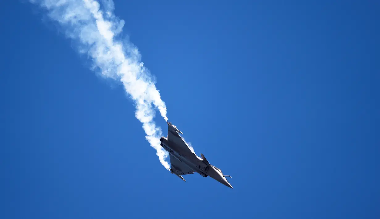 Angkatan Udara Prancis bermanuver menggunakan Dassault Rafale di atas Pantai San Lorenzo di Gijon, Spanyol, Minggu (24/7). (REUTERS/Eloy Alonso)
