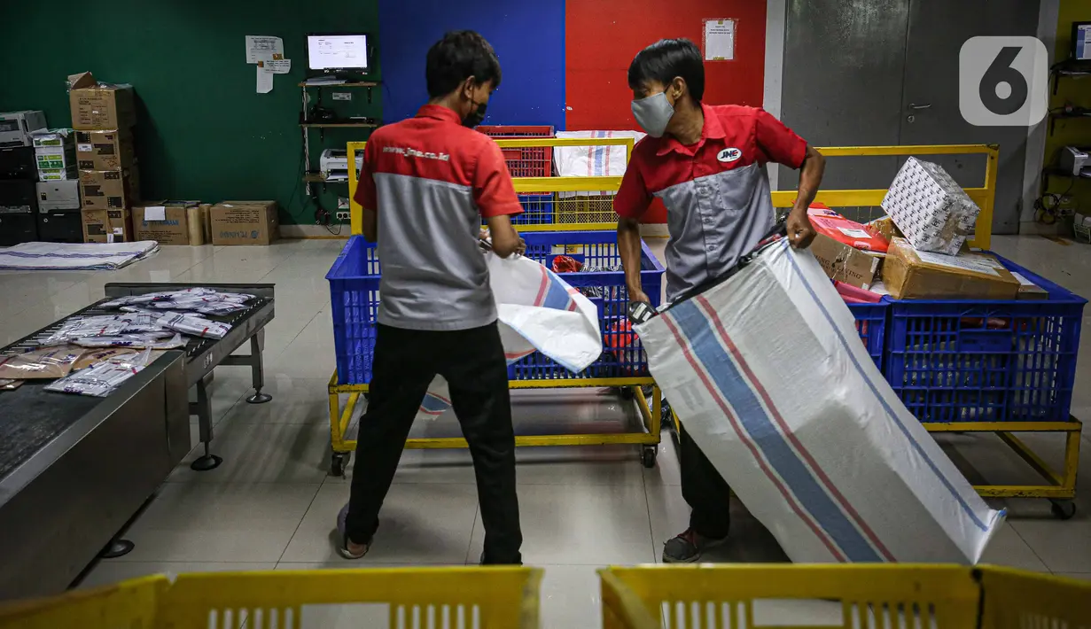 Pekerja memilah paket kiriman barang di Kantor Cabang JNE, Jakarta, Kamis (30/12/2021). Supply Chain Indonesia (SCI) memprediksi peningkatan pengiriman barang pada akhir tahun ini mencapai 20 persen untuk ke wilayah luar Pulau Jawa dan Bali. (Liputan6.com/Faizal Fanani)