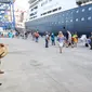 Seorang turis mengabadikan gambar seniman bermain alat musik tradisional di Pelabuhan Tanjung Priok, Jakarta, Kamis (7/1/2016). Para turis akan melanjutkan perjalanan menuju Semarang dan pemberhentian terakhir yaitu Bali. (Liputan6.com/Faizal Fanani)