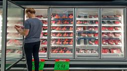 Seorang pelanggan memeriksa bagian daging sapi sebuah supermarket di Curitiba, Brasil, Kamis (23/2/2023). Otoritas Brasil dalam sebuah pernyatakan mengungkapkan bahwa mereka akan mengadakan percakapan dengan pihak China dalam upaya untuk memulihkan arus perdagangan yang terganggu penyakit sapi gila itu. (Photo by Eduardo Matysiak / AFP)