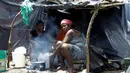 Dua migran Afrika yang terdampar di Kosta Rika memasak makanan di tenda mereka di sebuah kamp darurat di perbatasan antara Kosta Rika dan Nikaragua, di Penas Blancas, Kosta Rika, (14/7). (REUTERS / Juan Carlos Ulate)