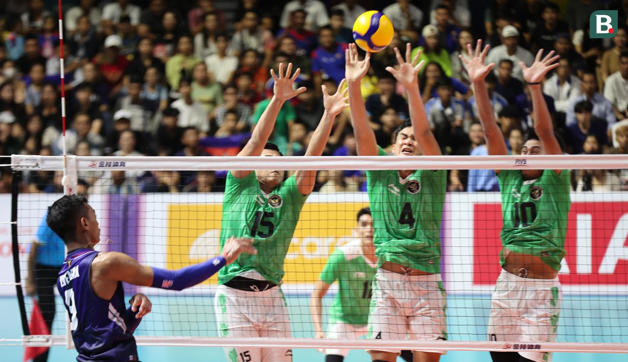 Tiga pemain tim bola voli putra Indonesia (kiri ke kanan) Dio Zulfikri, Hendra Kurniawan dan Fahri Septian berusaha memblok spike yang dilepaskan pemain Kamboja pada laga ketiga Grup A SEA Games 2023 di Olympic Complex Indoor Main Hall, Phnom Penh, Kamboja, Sabtu (6/5/2023). Tim bola voli Putra Indonesia menang 3-0 (25-18, 25-21, 25-16) dan memastikan lolos ke semifinal sebagai juara Grup A. (Bola.com/Abdul Aziz)