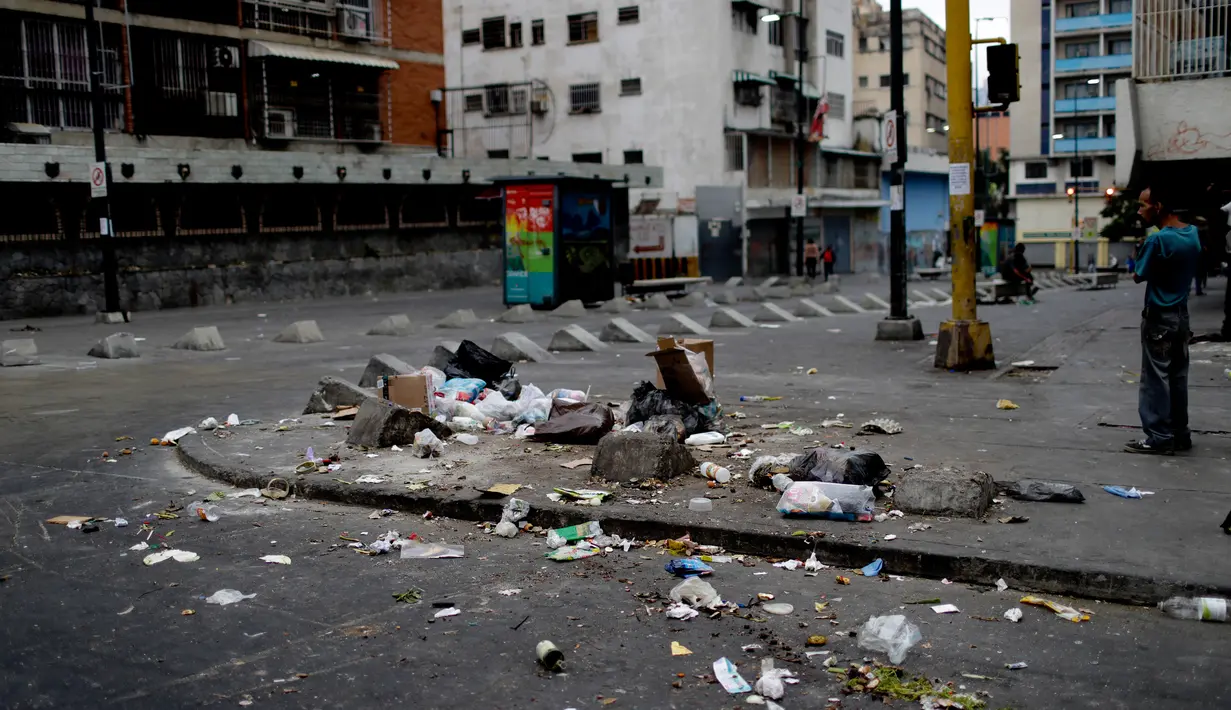 Sampah mengotori jalan dan trotoar di Caracas, Venezuela, Senin (25/3). Warga miskin yang kelaparan akibat krisis mencari makanan dari sisa sampah rumah tangga. (AP Photo/Natacha Pisarenko)
