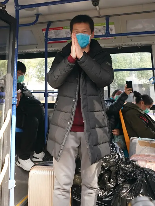 Seorang pasien virus corona yang telah pulih memberi salam kepada para pekerja medis dari dalam bus setelah meninggalkan rumah sakit sementara Wuchang di Wuhan, Provinsi Hubei, China tengah (10/3/2020). (Xinhua/Wang Yuguo)