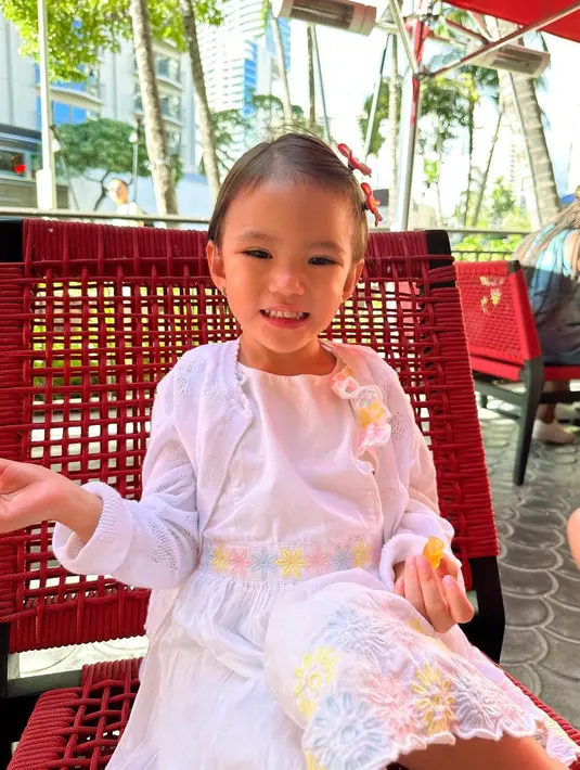 Putrinya, Claire tak kalah menawan mengenakan gaun warna putih bercorak bunga dan cardigan warna senada.  [Instagram/shandyaulia]