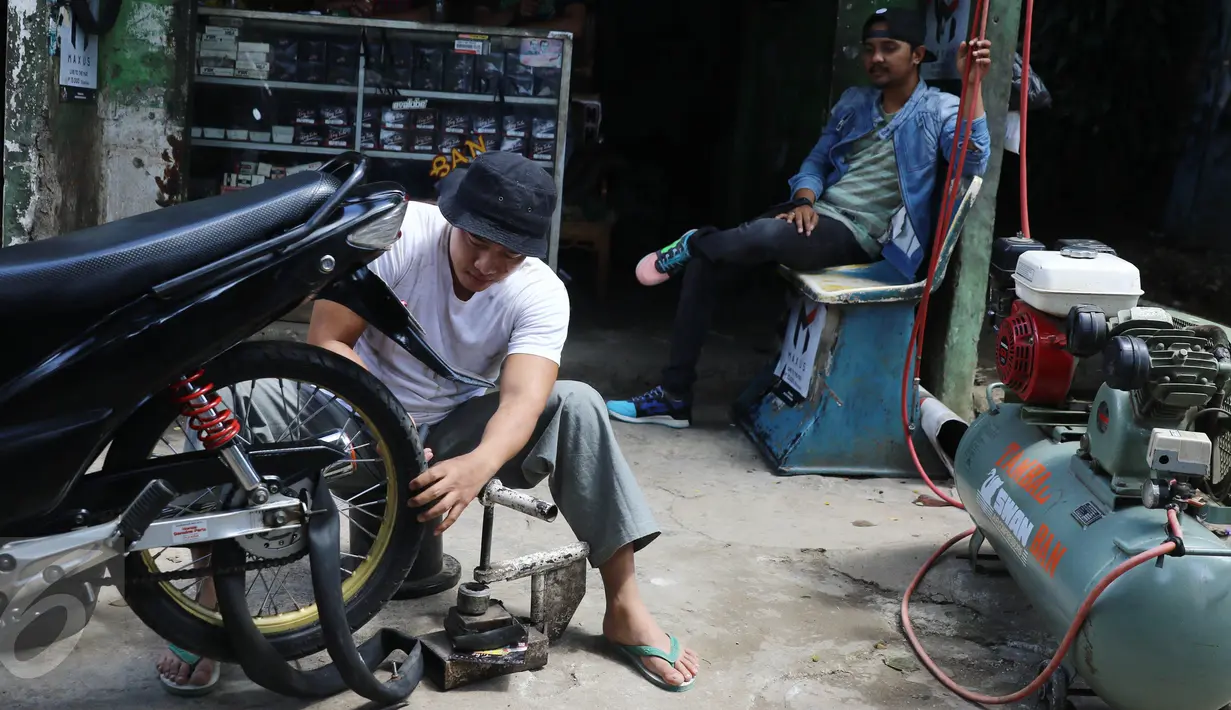 Vokalis band Repvblik, Ruri menjadi tukang tambal ban saat syuting pembuatan video klip 'Sayang Sampai Mati' di kawasan Depok, Jawa Barat, Kamis (19/1). (Liputan6.com/Herman Zakharia)