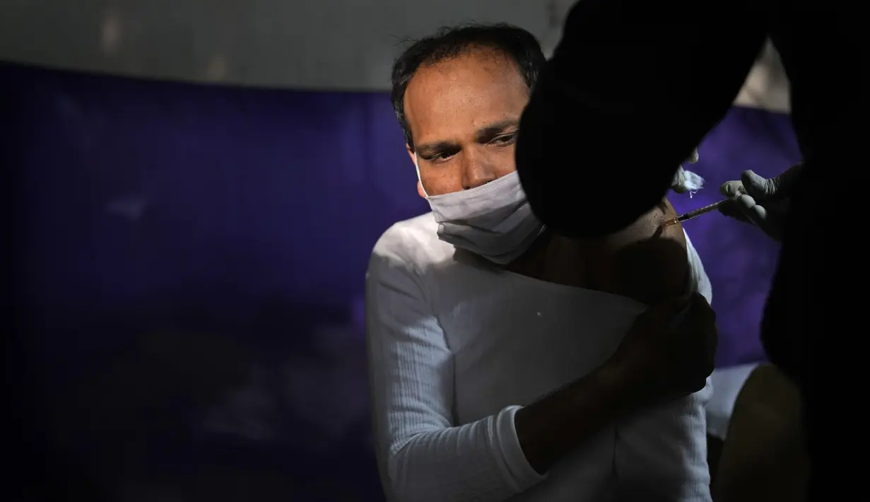 Tenaga medis menyuntikkan vaksin COVID-19 kepada seorang pria di sebuah pasar di New Delhi, Rabu (29/12/2021). Di India, yang telah kembali normal setelah dihantam tsunami COVID-19 tahun ini, omicron sekali lagi menimbulkan ketakutan, dengan lebih dari 700 kasus dilaporkan. (AP Photo/Manish Swarup)