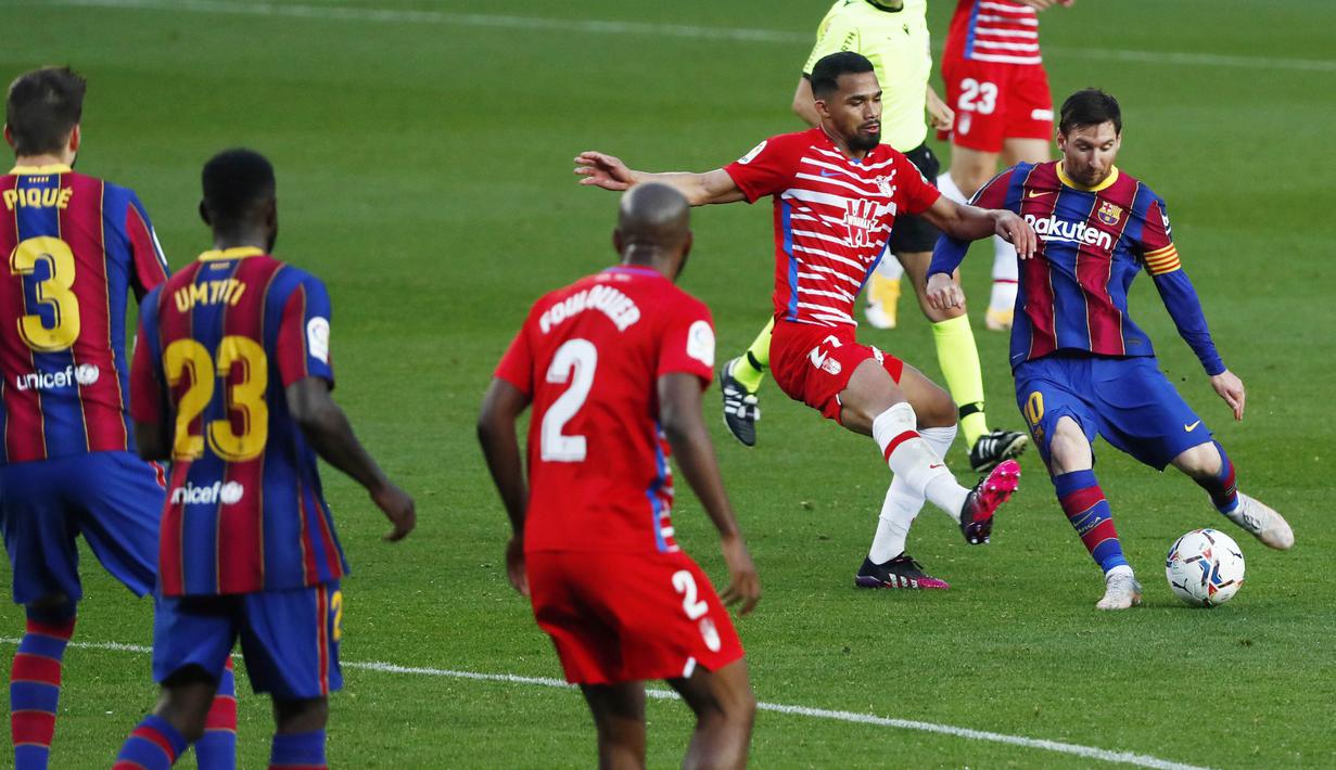 Striker Barcelona, Lionel Messi, melepaskan tendangan saat melawan Granada pada laga Liga Spanyol di Stadion Camp Nou, Jumat (30/4/2021). Barcelona takluk dengan skor 1-2. (AP/Joan Monfort)