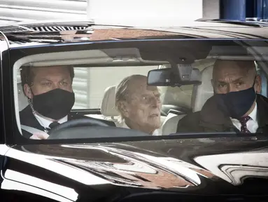 Pangeran Philip (tengah) berada di dalam mobil saat meninggalkan rumah sakit Prince Edward VII di London, Selasa (116/3/2021). Suami Ratu Elizabeth II yang berusia 99 tahun itu dirawat di rumah sakit selama empat pekan terkait infeksi dan operasi jantung. (Stefan Rousseau/PA via AP)