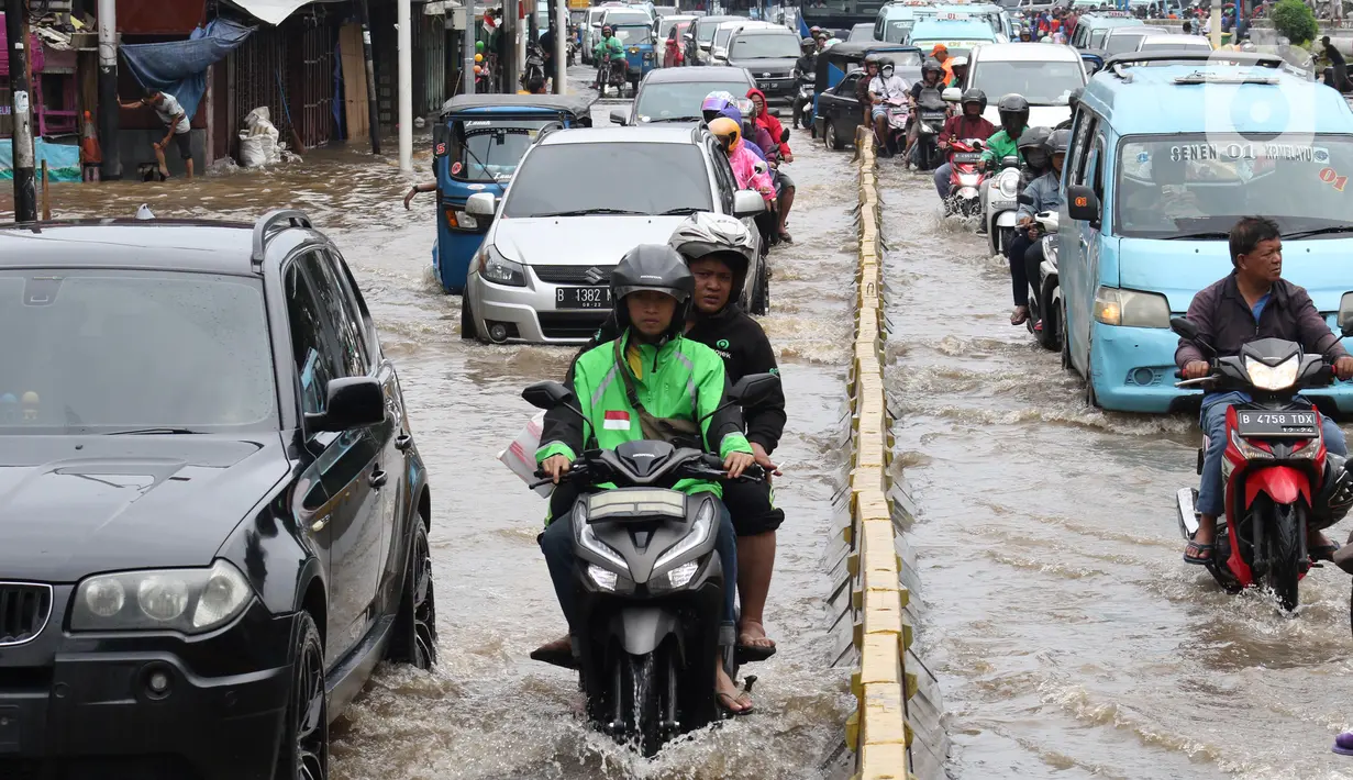 Pengendara menerobos genangan air di sebagian ruas Jalan Jatinegara Barat, Jakarta, Rabu Rabu (1/1/2020). Hujan yang mengguyur Jakarta sejak Selasa sore (31/12/2019) mengakibatkan banjir di sejumlah titik di Jakarta. (Liputan6.com/Helmi Fithriansyah)