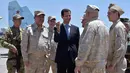 Presiden Suriah Bashar al-Assad berbincang dengan pasukan Rusia saat mengunjungi pangkalan udara Rusia di Khmeimim, Selasa (27/6). Kunjungan ini merupakan yang pertama kalinya Assad lakukan ke pangkalan. (Syrian Presidency via Facebook)