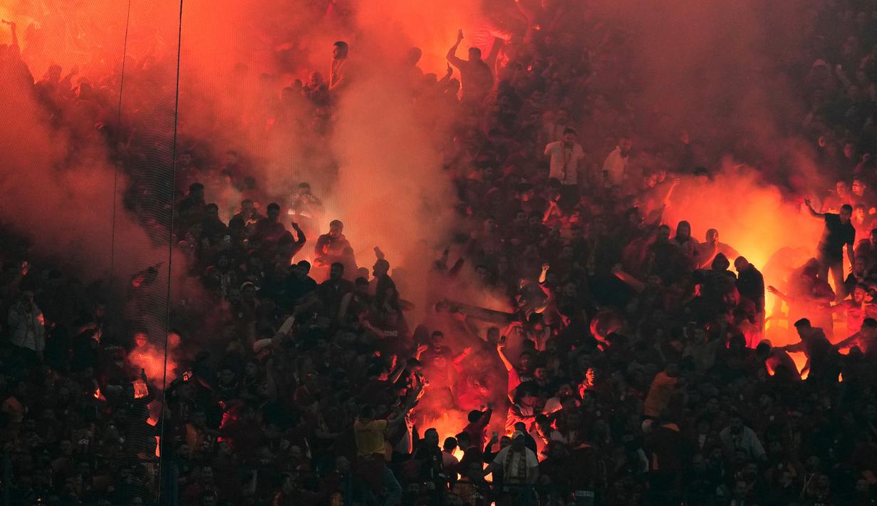 Para suporter Galatasaray menyalapan suar dalam laga lanjutan Liga Super Turki 2025/2026 antara Fenerbahce melawan Galatasaray di Chobani Stadium, Istanbul, Turki, Senin (01/12/2025) waktu setempat. (AP Photo/Khalil Hamra)