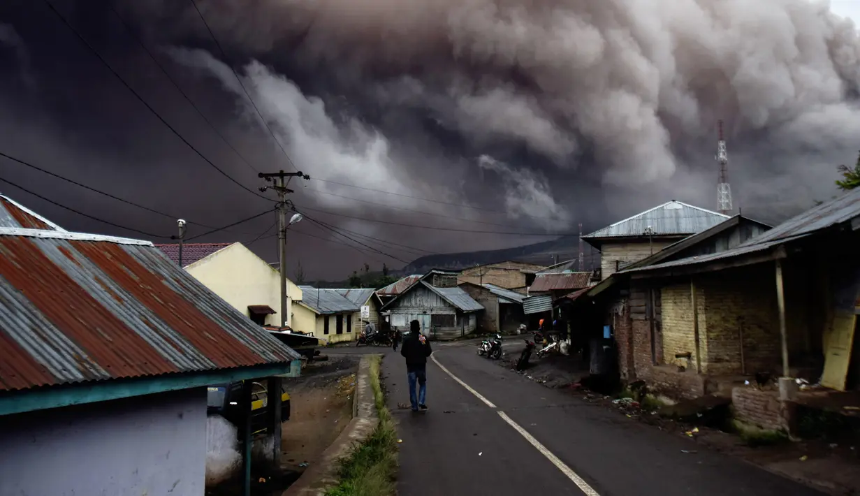  Warga beraktivitas di dekat kawasan Gunung Sinabung yang kembali mengalami erupsi, Karo, Sumatera Utara (1/11). Gunung Sinabung kembali mengalami erupsi. Luncuran awan panas beserta material vulkaniknya mencapai 1.000 meter. (AFP Photo/Satar Ginting)