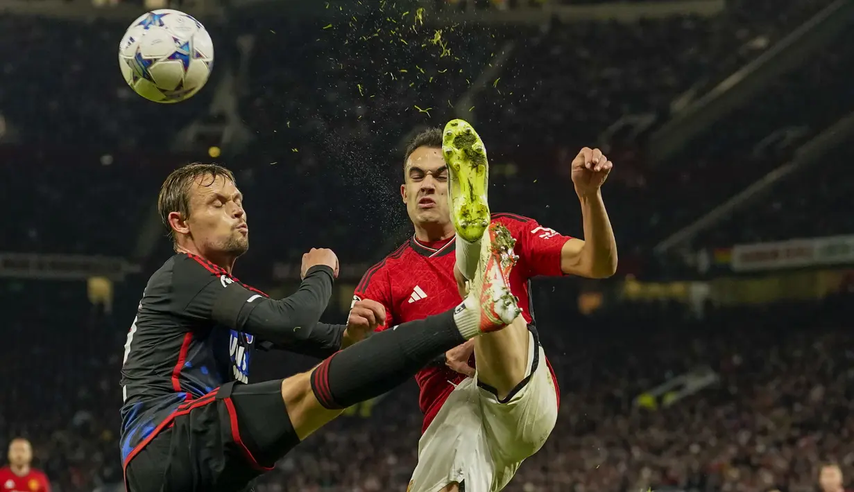 Bek FC Copenhagen, Peter Ankersen (kiri) berebut bola dengan bek Manchester United, Sergio Reguilon pada laga matchday ketiga Grup A Liga Champions 2023/2024 di Old Trafford Stadium, Rabu (25/10/2023) dini hari WIB. (AP Photo/Dave Thompson)
