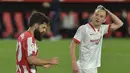 Gelandang Sevilla, Ivan Rakitic (kanan) bereaksi di samping penyerang Athletic Bilbao, Asier Villalibre pada pertandingan La Liga Spanyol di stadion Ramon Sanchez Pizjuan, Seville, Selasa (4/5/2021). Kekalahan atas Bilbao, membuat Sevilla gagal mendekati tiga tim teratas Liga Spanyol. (AFP/Cristina