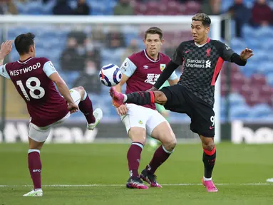 Penyerang Liverpool, Roberto Firmino ditantang oleh gelandang Burnley, Ashley Westwood pada pekan ke-37 Liga Inggris di Stadion Turf Moor, Kamis (20/5/2021) dini hari WIB. Liverpool sukses menembus empat besar klasemen Liga Inggris setelah menang telak 3-0 atas Burnley. (Alex Livesey/Pool via AP)