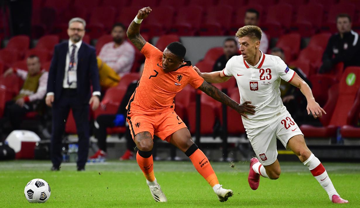 Penyerang Belanda, Steven Bergwijn, berebut bola dengan penyerang Polandia, Krzysztof Piatek, pada laga UEFA Nations League di Stadion Johan Cruijff Arena, Amsterdam, Sabtu (5/9/2020) dini hari WIB. Belandang menang 1-0 atas Polandia. (AFP/John Thys)