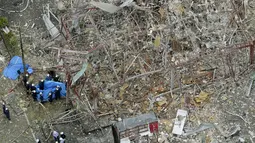 Penyelidik bekerja di lokasi ledakan di Koriyama, Prefektur Fukushima, Jepang utara, Kamis, (30/7/2020). Setidaknya lebih dari puluhan orang terluka dan dibawa ke rumah sakit setelah ledakan akibat kebocoran gas menghantam dinding, jendela, dan bangunan di lingkungan tersebut. (Berita Kyodo via AP)
